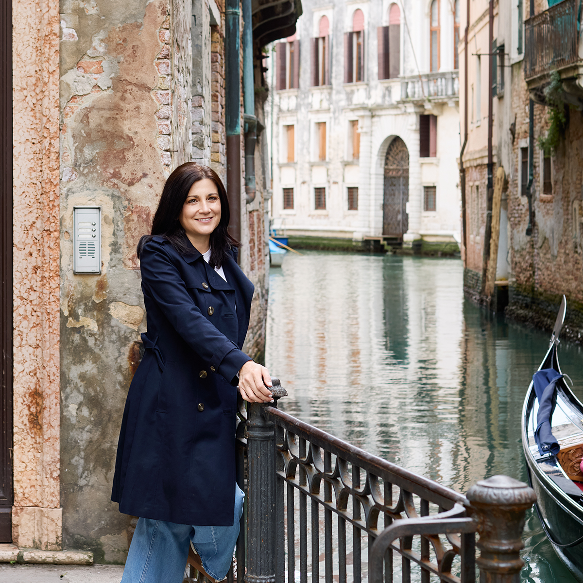 Elena in a blue trench coat in Venice.