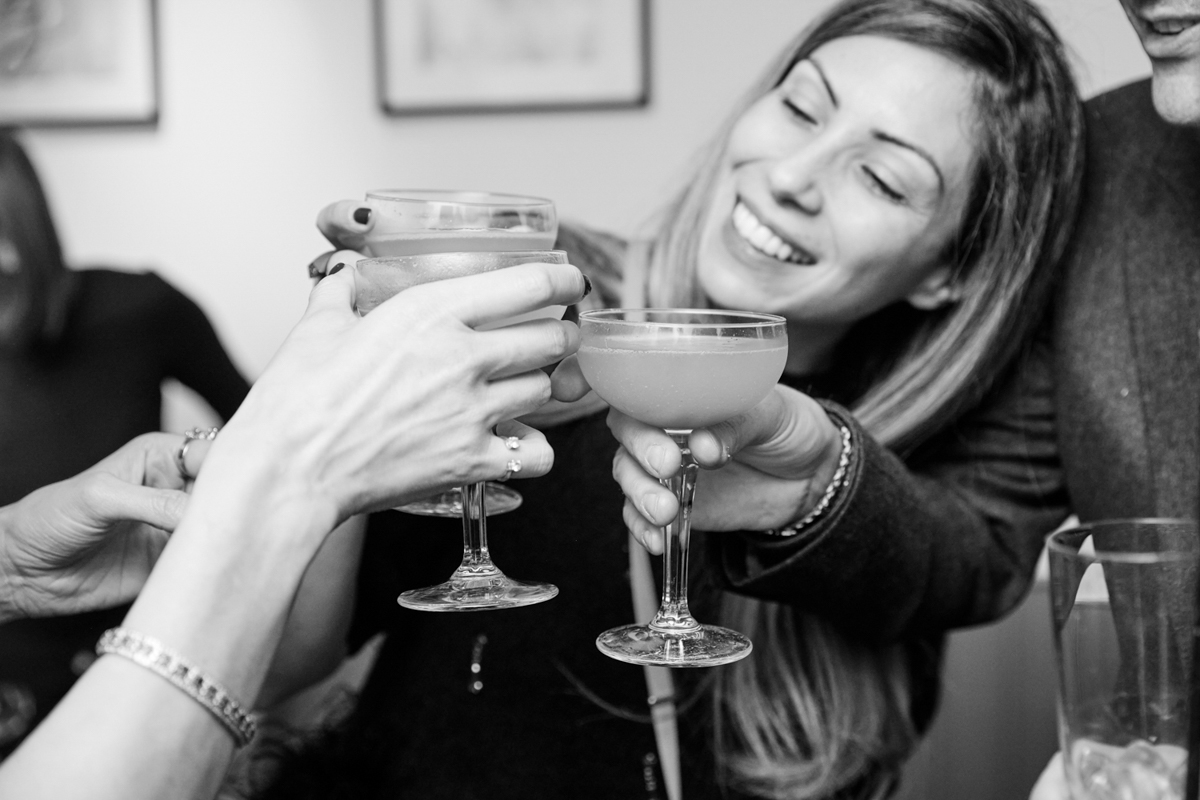 A close up of clinging champagne glasses held by a lady during a birthday party in a London restaurant