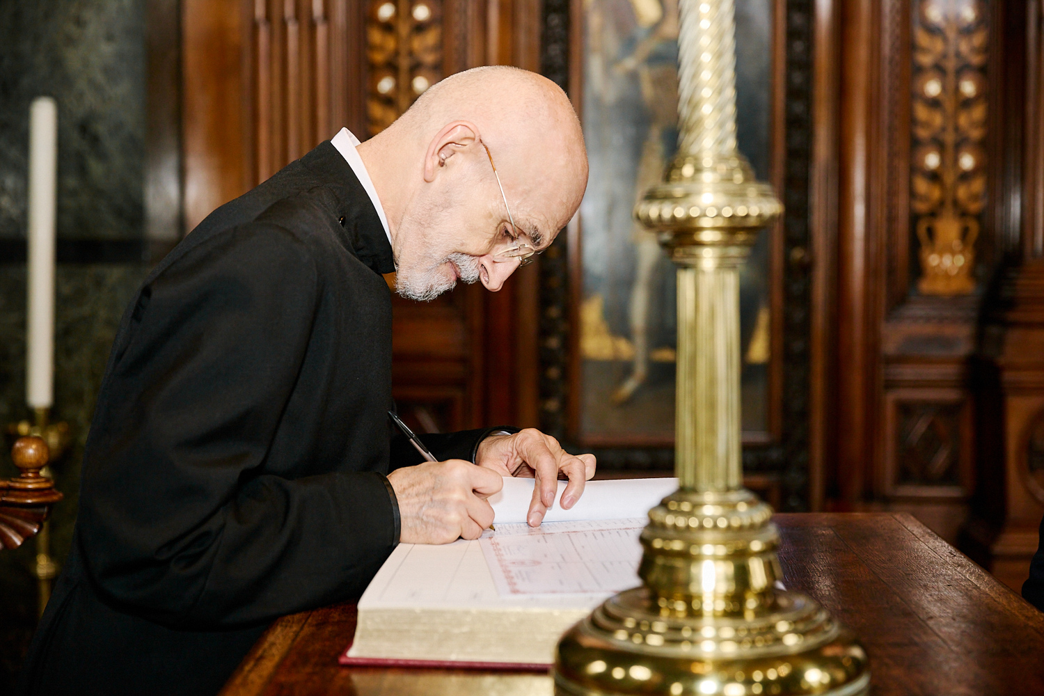 A priest signing some documents.