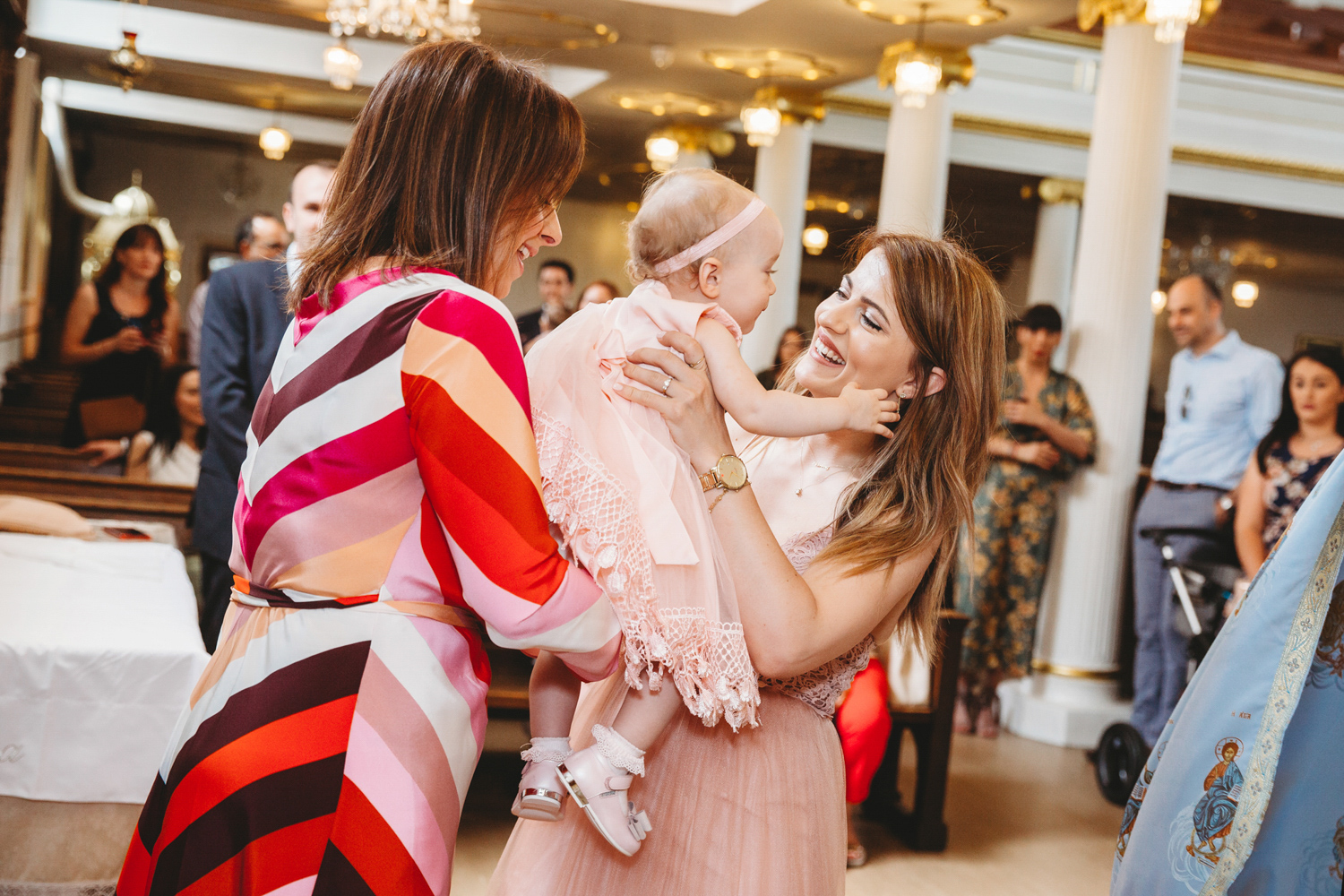 Woman giving baby girl back to her mum after her christening.