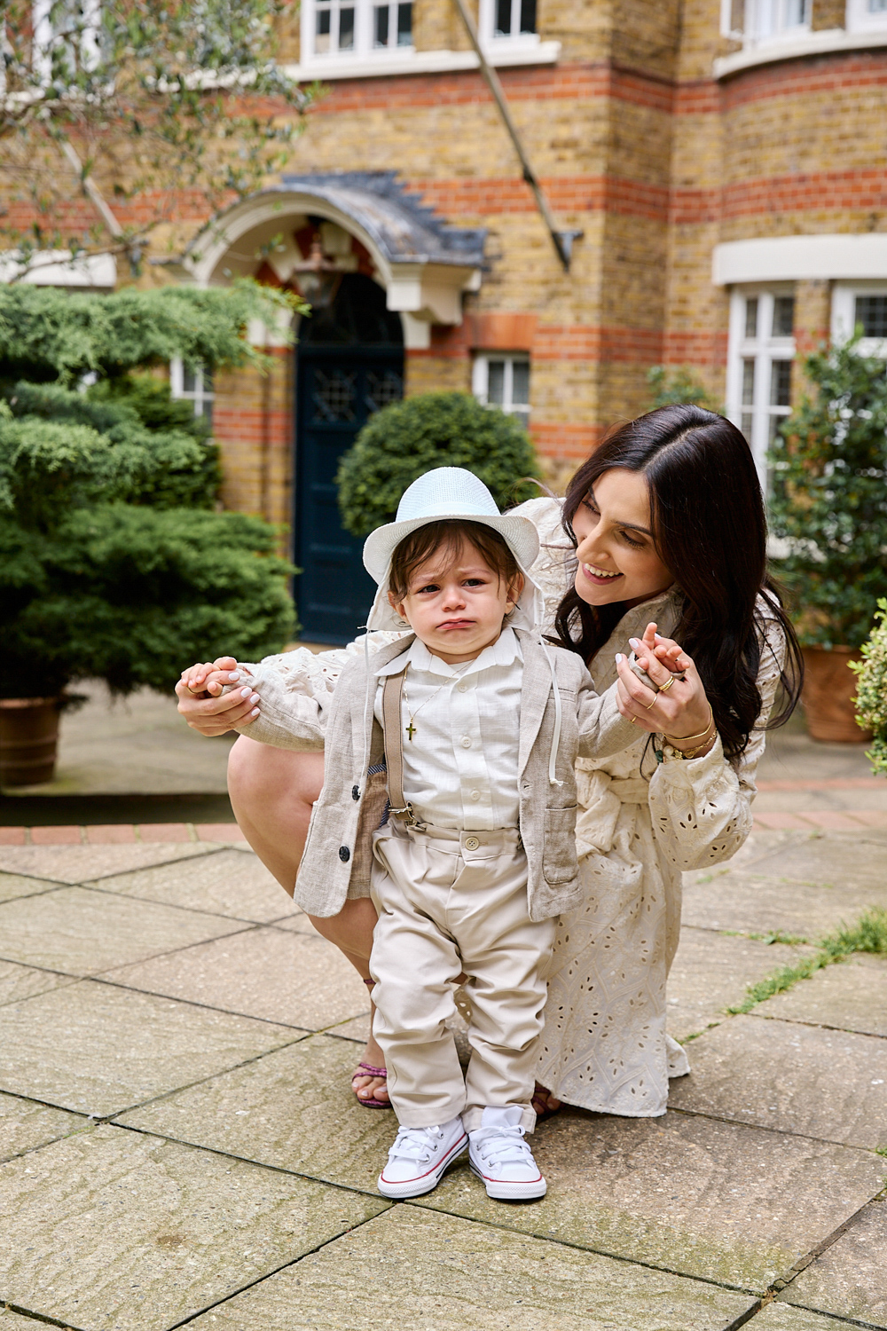 Little boy held by his godmother outside a church.