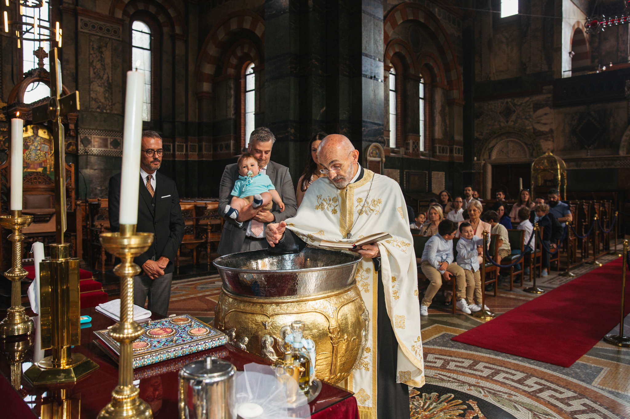 Priest blessing the baptismal font.