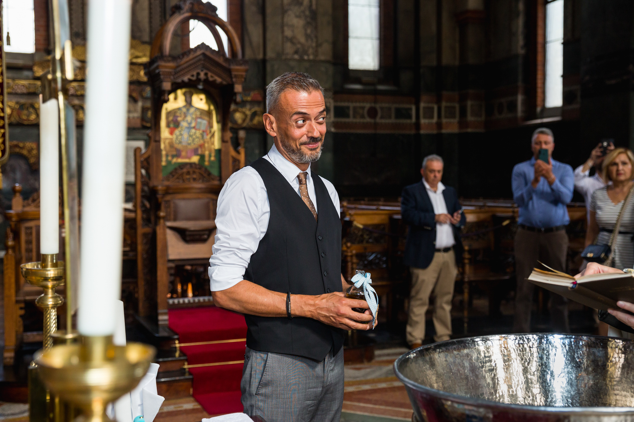 Godfather observing the christening ceremony.