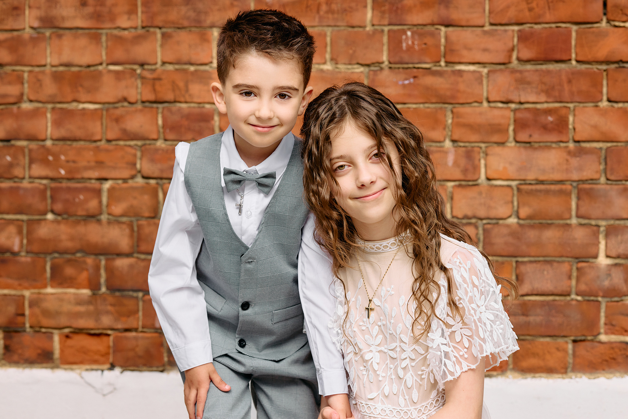 A boy and a girl dressed up in fron t of a church.