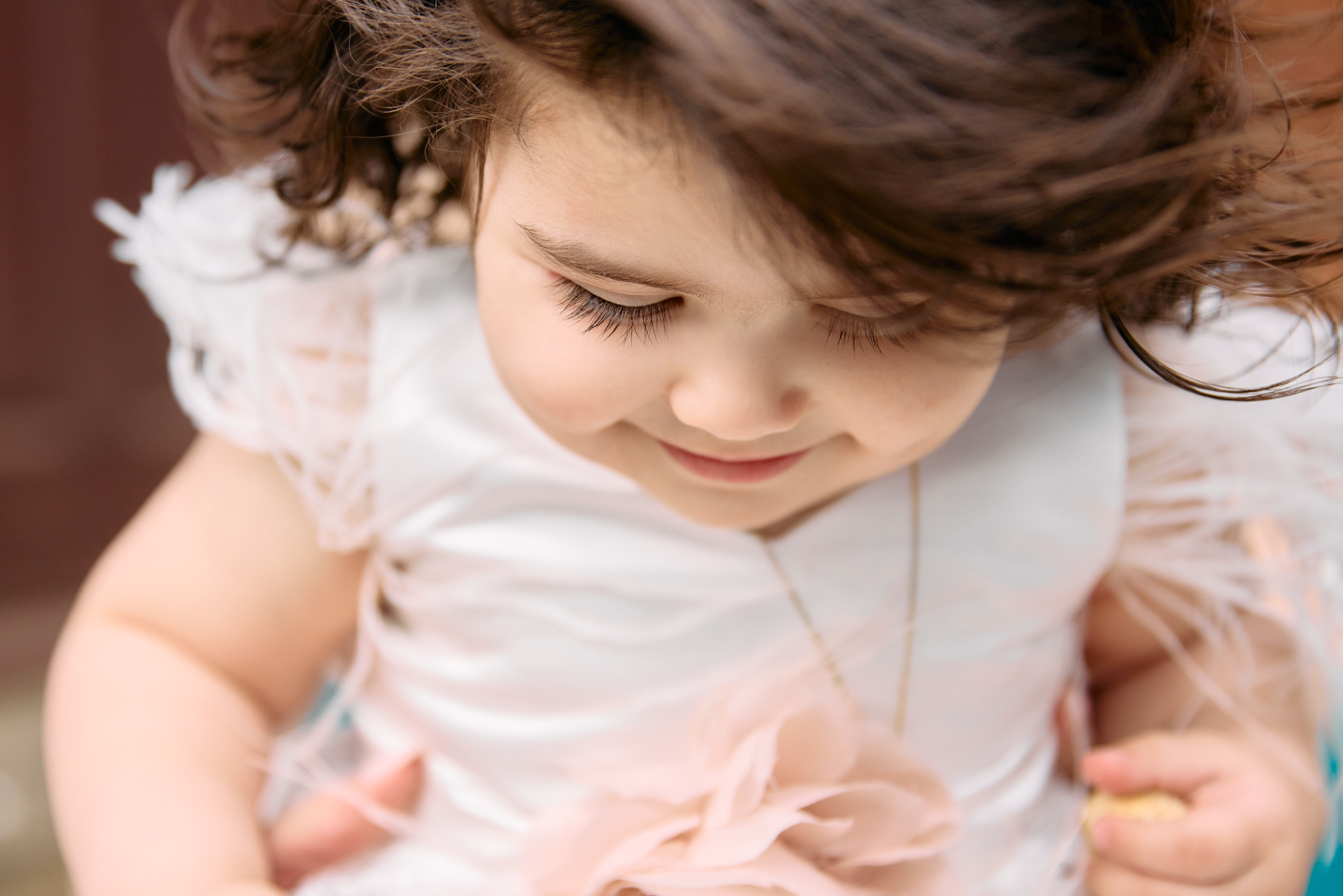 Close up of a little girl looking down after her christening.