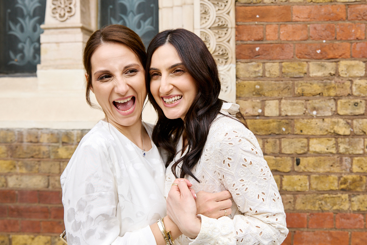 2 ladies laughing in front of of a church.