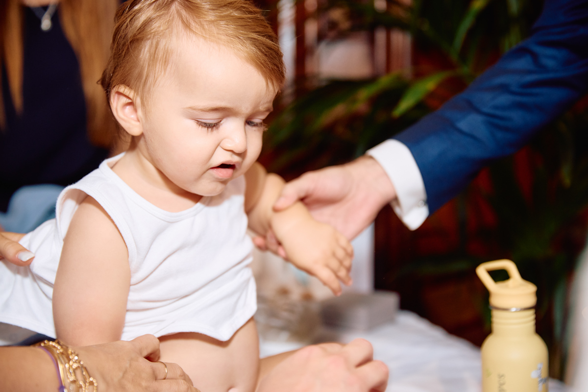 Little boy getting dressed after his christening.