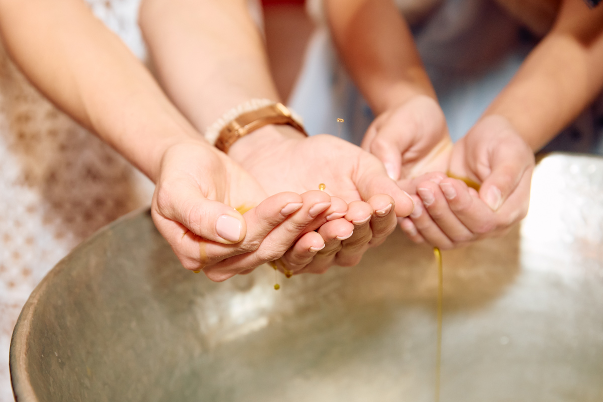 Close up of hands covered in sacred oil.