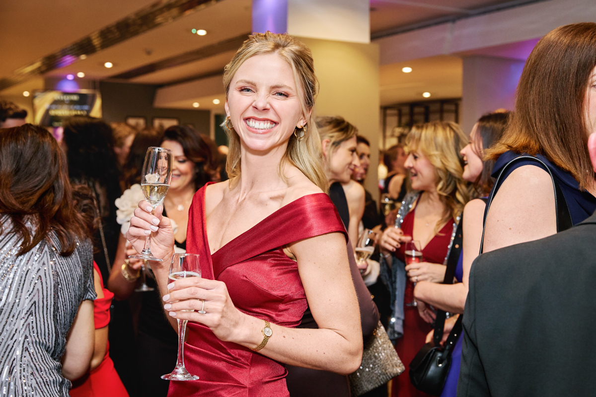 Lady smiling holding a glass of champagne during an even at Epsom downs