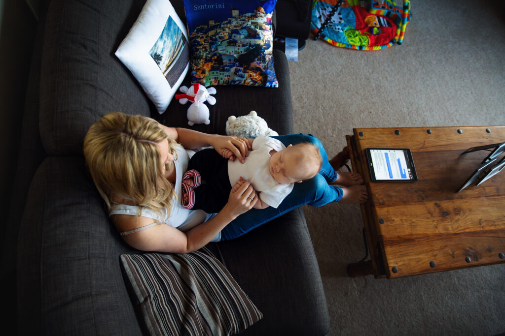 Top view of a baby sleeping on his mum lap in the house in Wimbledon.