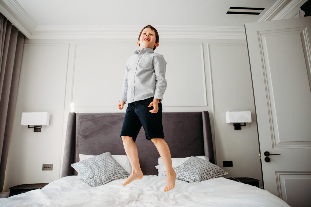Little boy jumping on mum and dad's bed.