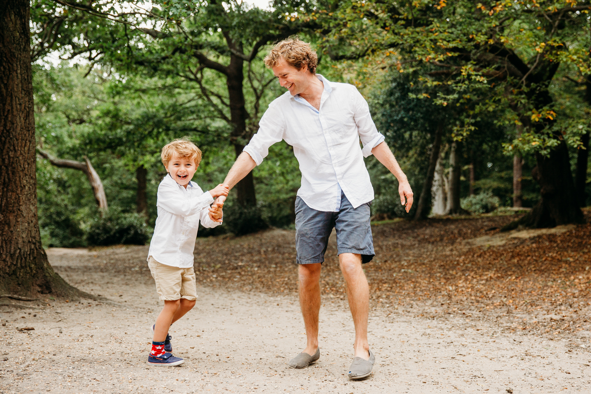 Dad and little boy walking playfully and having fun at the park.