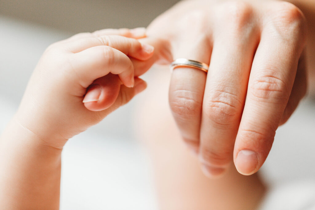 A close up of a baby hand touvhing his mum's finger.