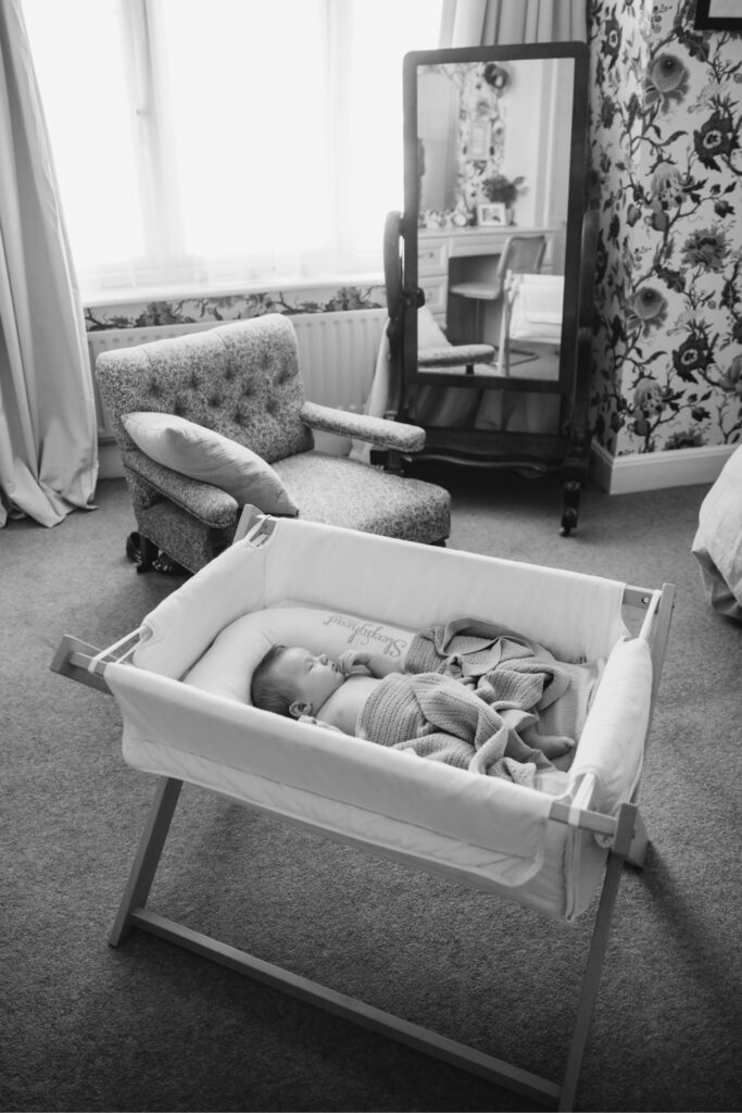 A baby sleeping peacufully in his vintage cot.