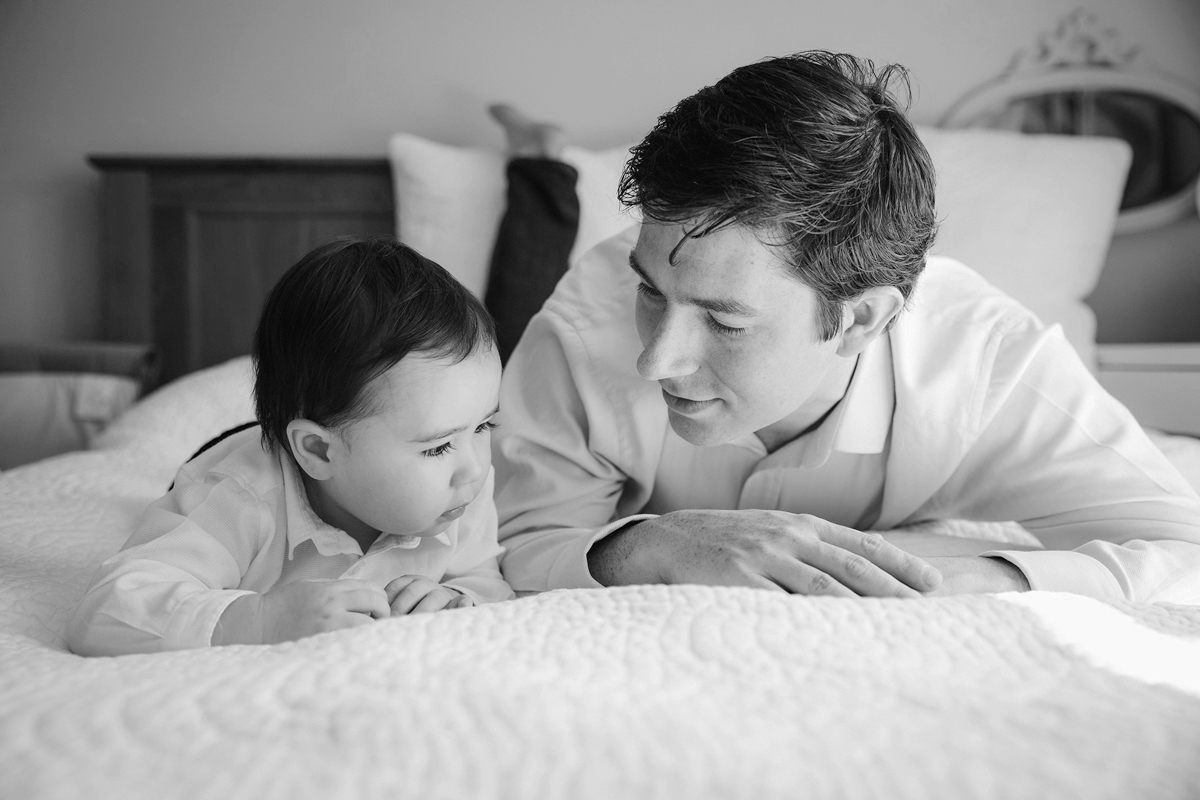 family photography London dad and little boy lying  on their tummies on bed at home